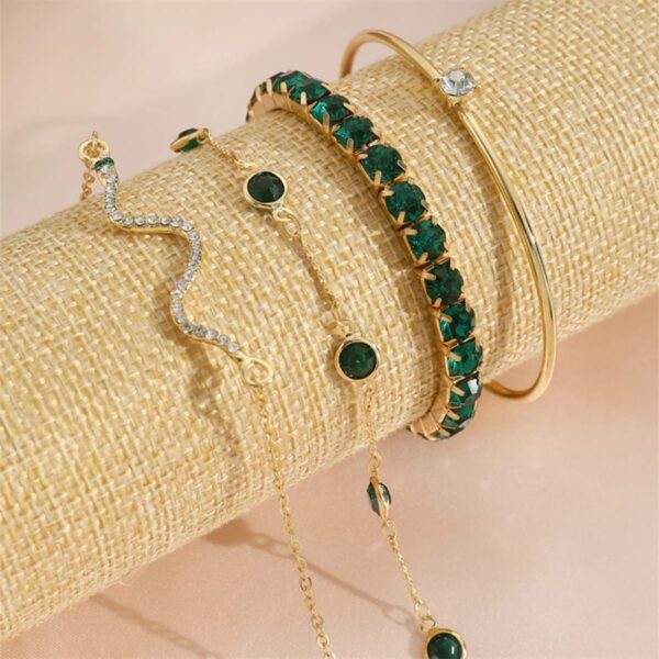 Pulseiras de cobra Concept Áurea com strass verde compondo um look elegante.